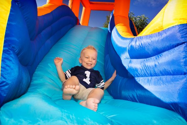 Boy sliding down an inflatable Dry Slide rental