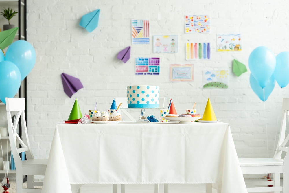 Festive cake on table in room decorated for birthday party